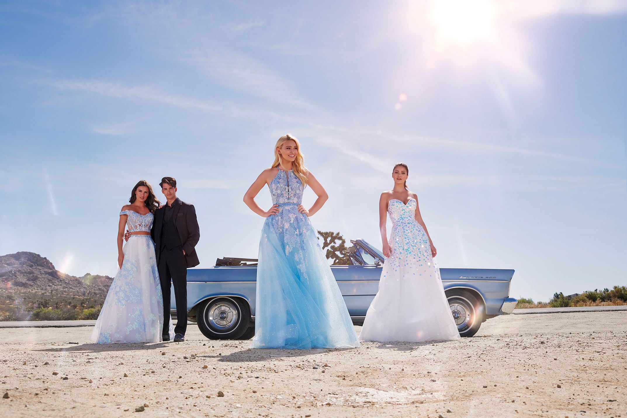 Models in Ellie Wilde dresses in front of a car in the desert